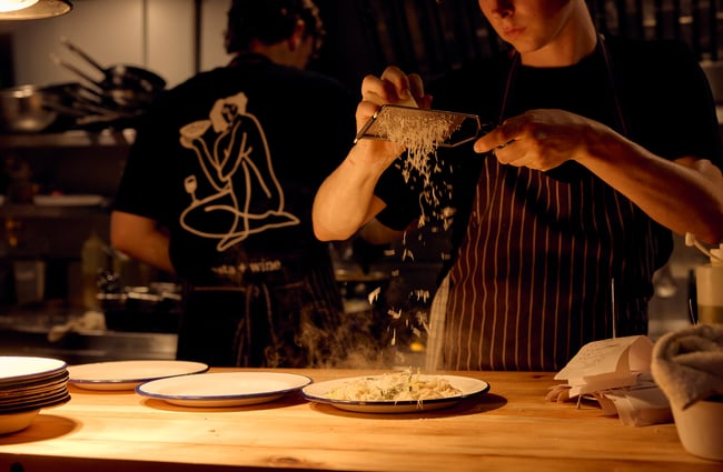 Chef grating cheese on top of cacio e pepe at Pici in Auckland