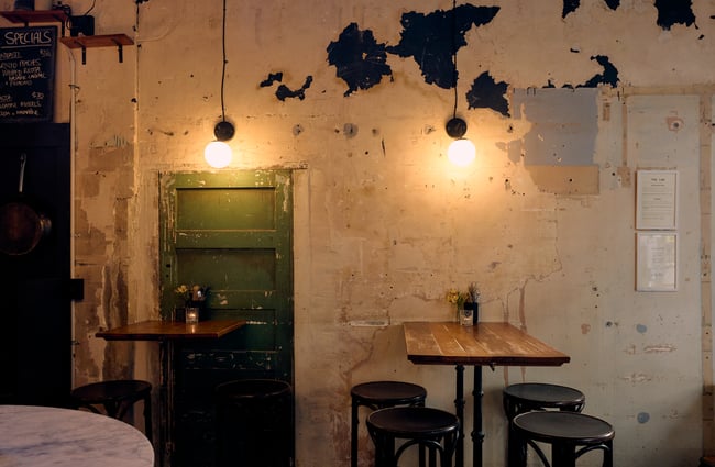 Empty dining table and distressed concrete wall inside Pici in Auckland