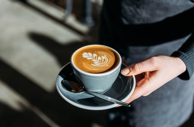 Barista holding a coffee at Pickle and Pie.
