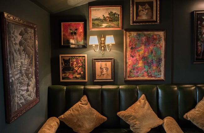 Artwork on wall by green leather booth.