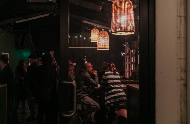 People sitting under ambient lights.
