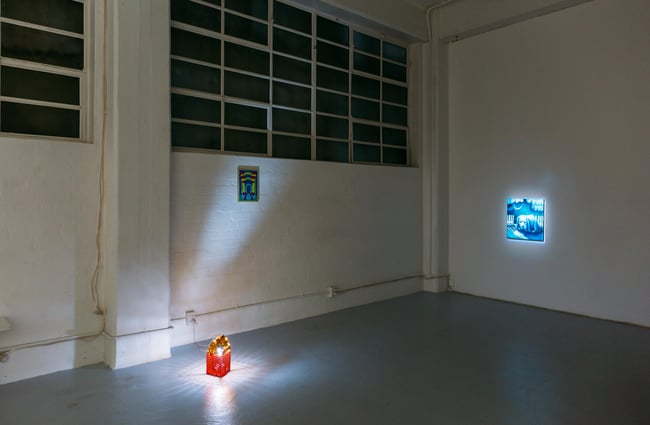 Artwork on display on white walls inside play_station gallery.