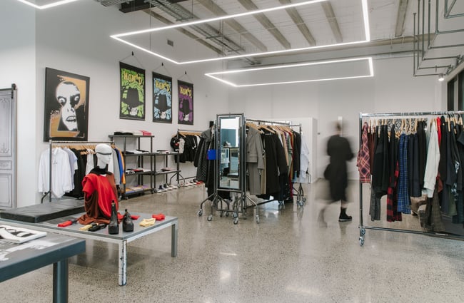 Mostly black clothes on racks scattered throughout the PLUME store in Christchurch.