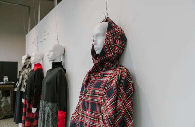 Mannequins wearing clothes against a wall.