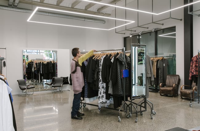 A staff member sorting through a rack of clothes.