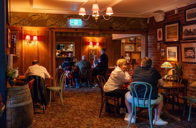 People seated at tables inside the cosy, dim interior of Pomeroy's.