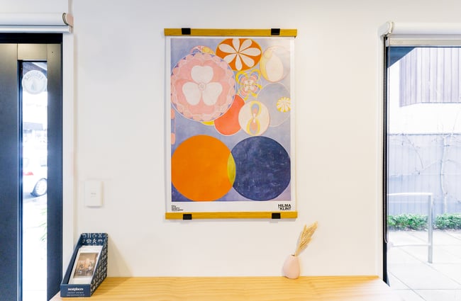 Colourful art on a wall inside a small cafe space.