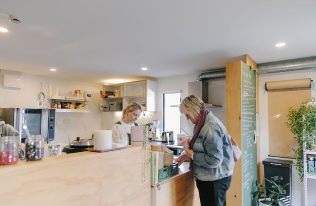 Woman paying at the till at Posh Porridge.