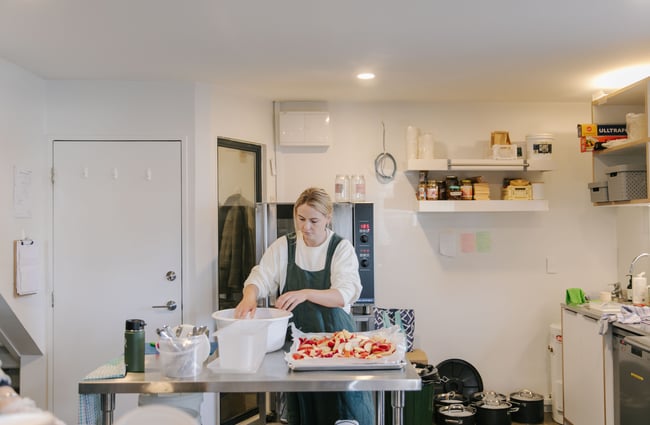 Woman preparing food in the kitchen at Posh Porridge