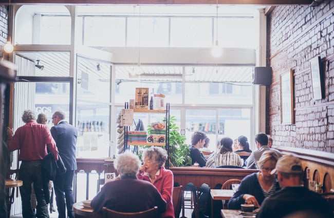 Inside of restaurant by windows and brick walls.