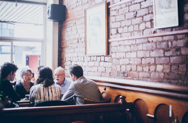Artwork on brick walls by people dining in.