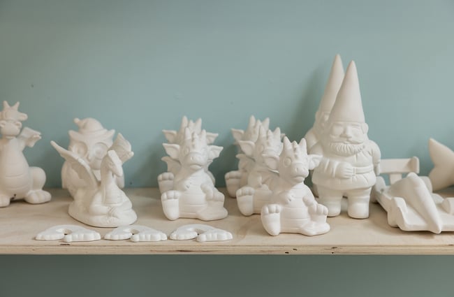 Ceramic character figures on a shelf at Pottery Capital.