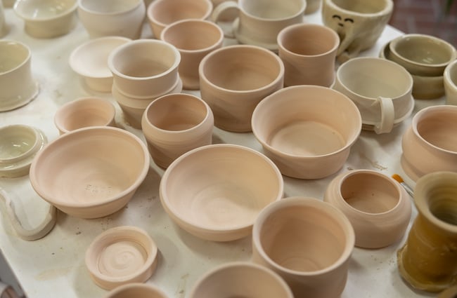 Table full of different sized ceramic pieces at Pottery Capital.