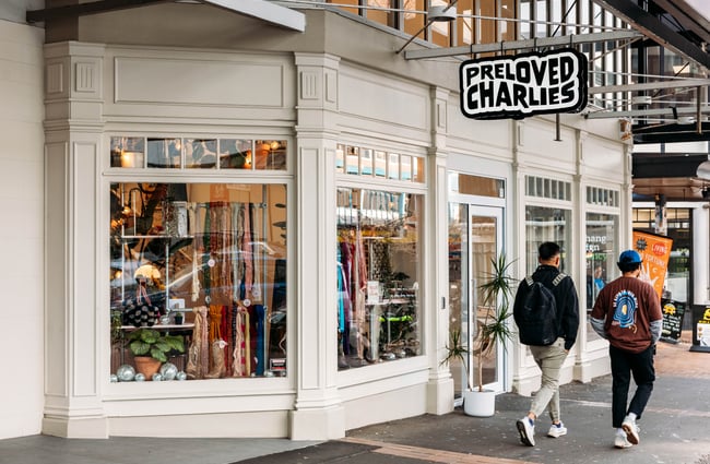 Pedestrians on the footpath walking past shop exterior and signage of Preloved Charlies.