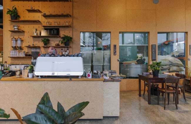 Barista behind the coffee machine at Prima Roastery.