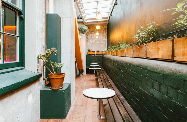 Courtyard with green walls and white tables.