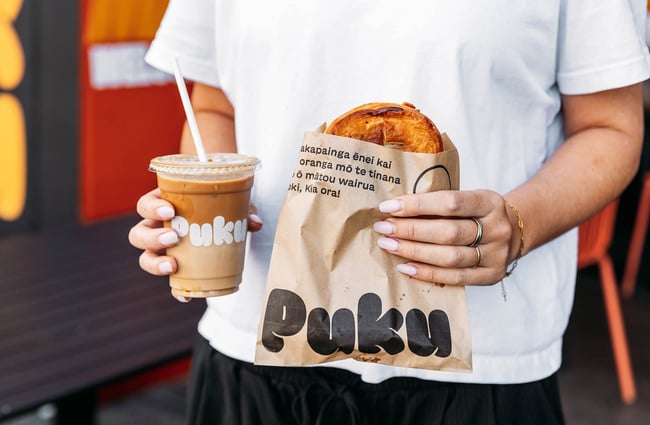 Someone holding pie and iced drink at Puku Pies in Petone