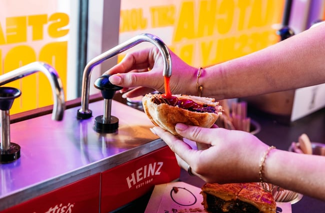Sauce being dispensed onto pie at Puku Pies in Petone