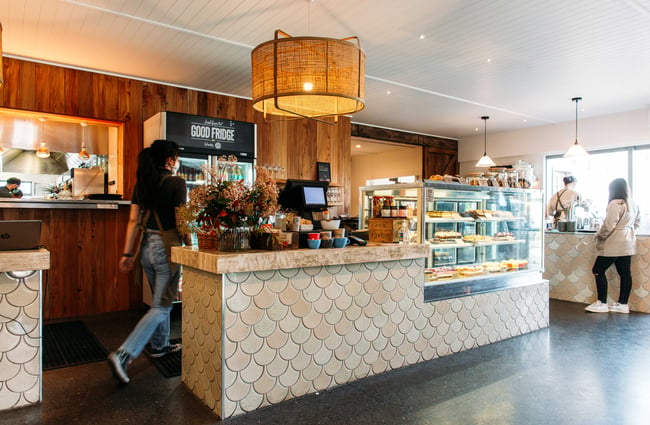 A staff member walking behind the counter at Punnet Eatery.