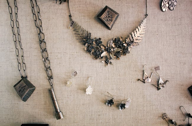 Silver jewellery displayed on cream coloured cloth.