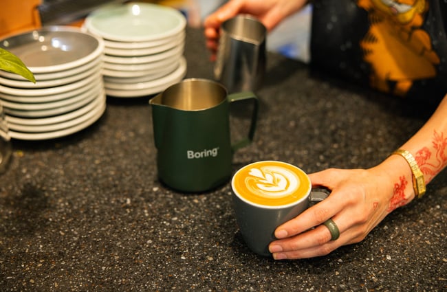 Barista making a coffee with Boring Oat Milk at Quail Cafe.