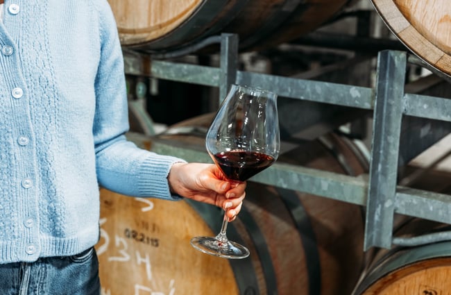 Customer holding a glass of wine at Quartz Reef.