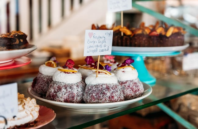 Close up of pink lamingtons on counter at Queen Sally's Diamond Deli in Lyall Bay Wellington