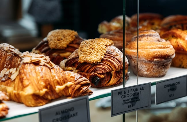A close up of pastries behind a glass counter.