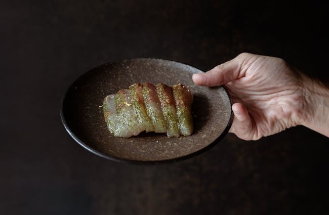 Chef holding up plate of sashimi