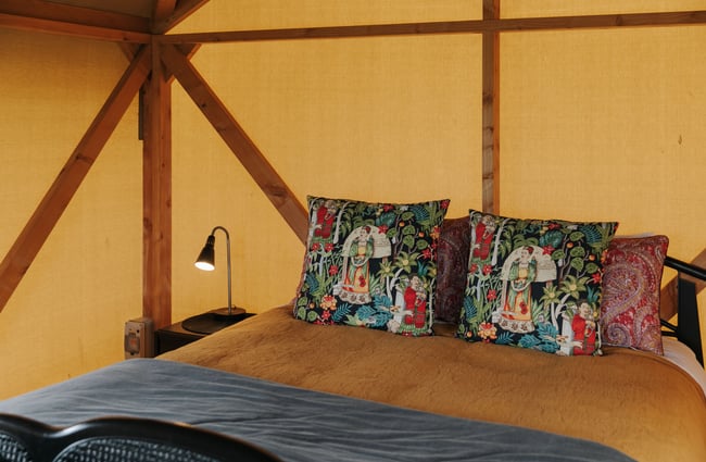 Inside a hut with cushions that are blue with red and white patterns