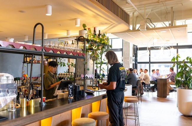 Customer standing at the bar ordering at The Rambler.