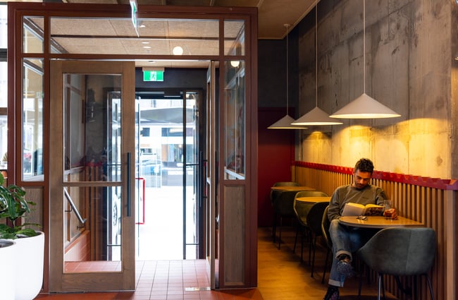 Customer sitting at a table by the door at The Rambler.