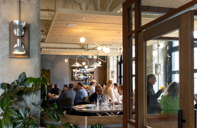 Guests sitting at tables in the bar area at The Rambler.