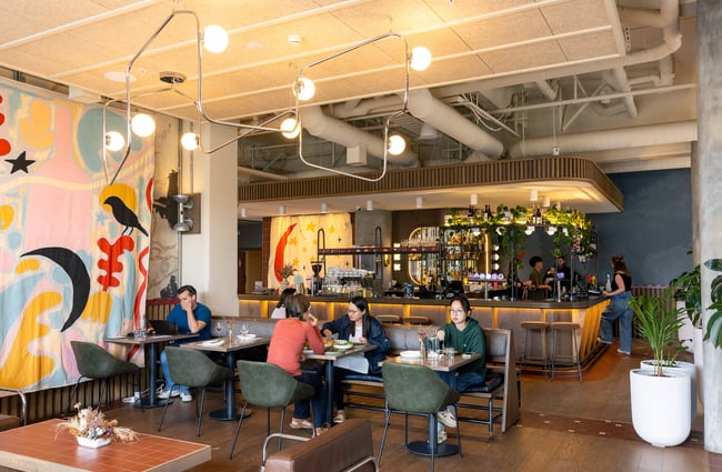 Guests sitting at tables in the bar area area at The Rambler.