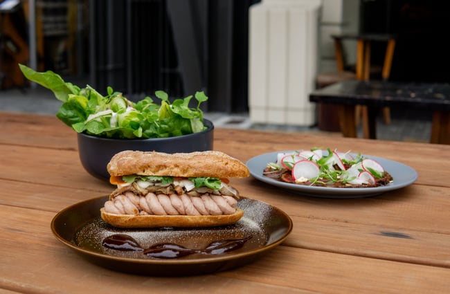 Three plates of food on an outside table.