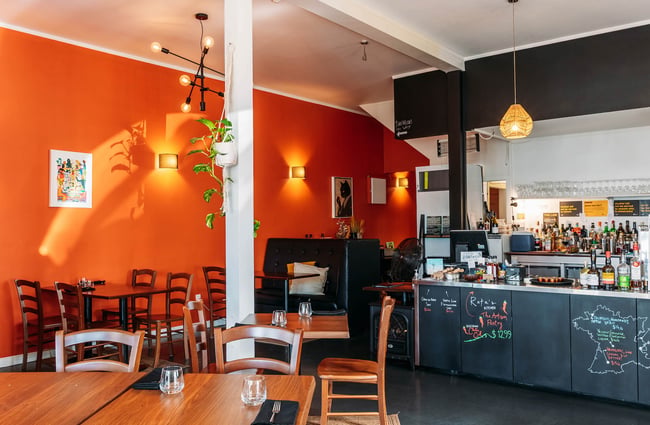 Bright orange wall in dining room at Rata's Kitchen in Petone