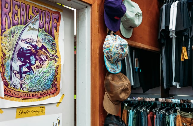 A close up of hats and a poster on a wall.