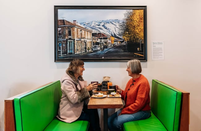 Customers sitting at a booth at Recharge Bar & Cafe.