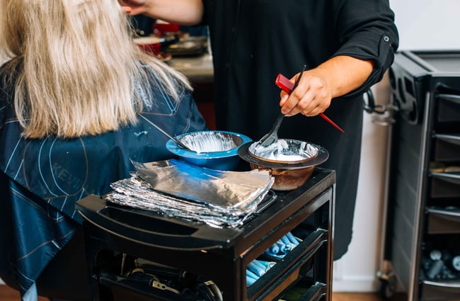 Woman using colour dye in bowls.