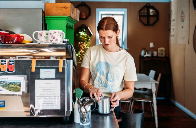 A young woman making coffee inside Relish cafe in Rangitikei.