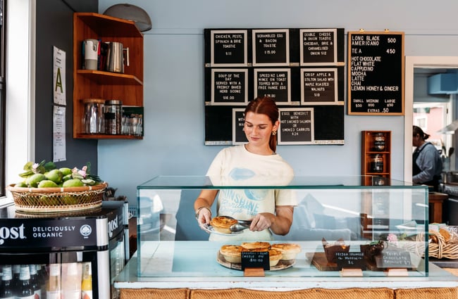 A young woman serving a pie inside Relish cafe in Rangitikei.
