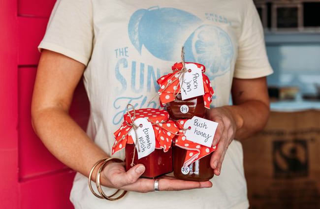 A woman holding three jars of chutney inside Relish cafe in Rangitikei.