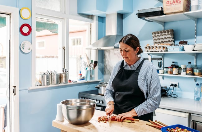 A woman cutting up rhubarb in the kitchen at Relish cafe in Rangitikei.