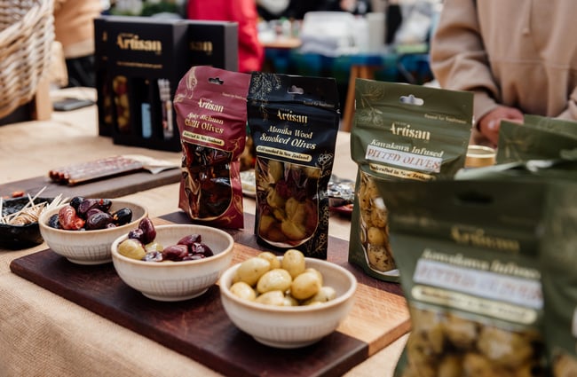 A close up of bowls of olives for sale.