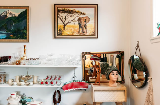 Antique artworks and homewares on display in a second hand store.