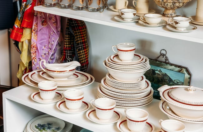 A close up of vintage plates and cups stacked.