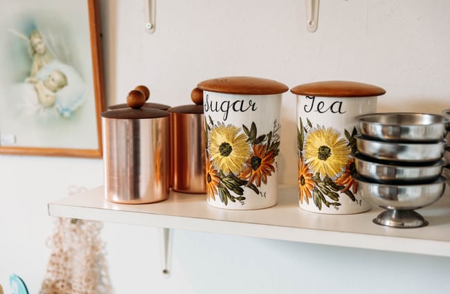 A close up of sugar containers decorated with yellow and brown flowers.