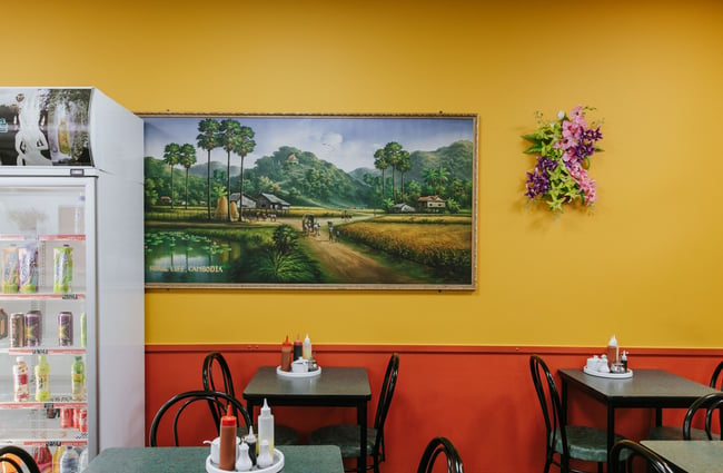 Tables and chair against a yellow and red wall.