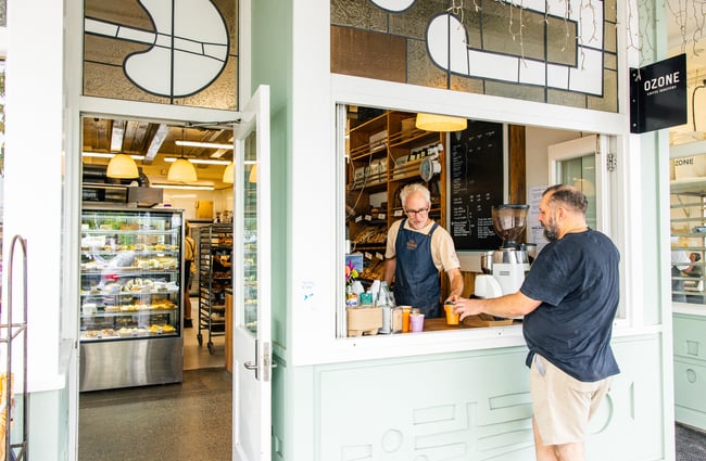 Barista handing a customer a coffee at Ringawera Baker.