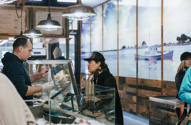 Woman buying food from a market stall.